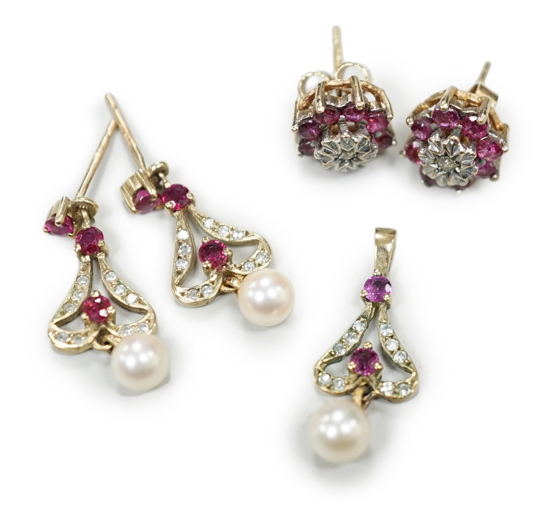 A modern 9ct gold, ruby, diamond and cultured pearl set drop pendant, 22mm and a pair of matching earrings, together with a pair of ruby and diamond cluster set ear studs, gross weight 5.7 grams.